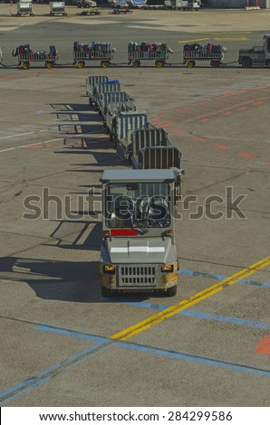 Baggage train in the international airport. Baggage trains are used to transport baggage from terminal to the plane
