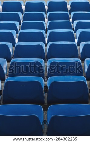 Some rows of empty seats in blue, seen from above