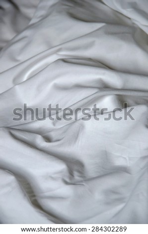 Texture of white fabric wrinkled. Bed sheet crumpled. Messy bed