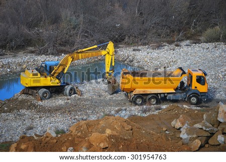Heavy machinery for construction and public works. Excavator and truck