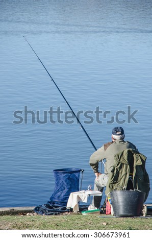 Fisherman fishing in a calm lake. Fishing is also a recreational sport