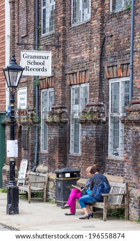 RYE, UK / 1st of JUNE 2014 - Two unknown women are sitting on a bench in front of the Grammar School Records shop