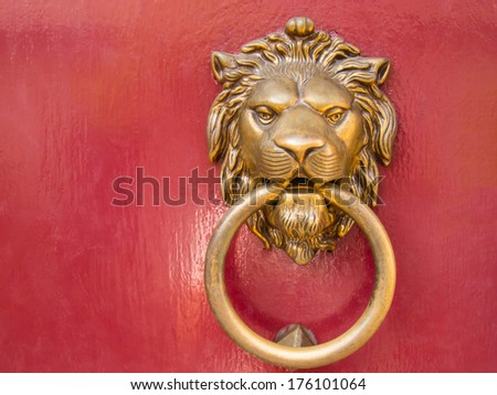 head gold lion knocks on the red door