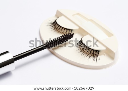 false eyelash set and mascara brush on grey background
