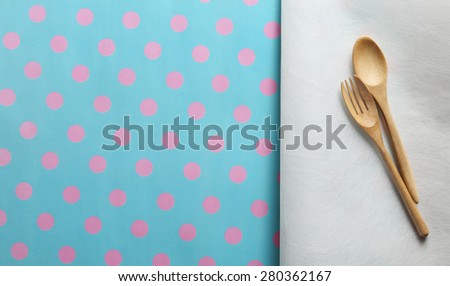 Wooden spoon and fork on white paper and paper placemat  pattern pink dot and cyan background. Menu set Concept