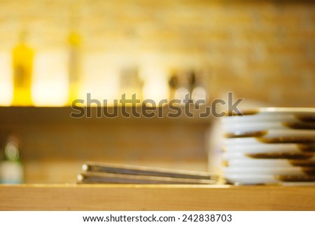 Abstract blurry restaurant counter with dishes and menu over it