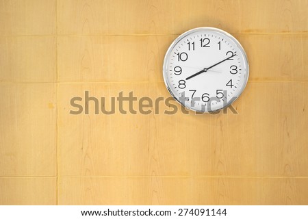 Abstract wooden wall with hanged clock in focus inside corporate meeting room