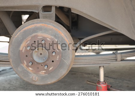Abstract closeup of rusty drum brake of truck with wheel removal on top of jack