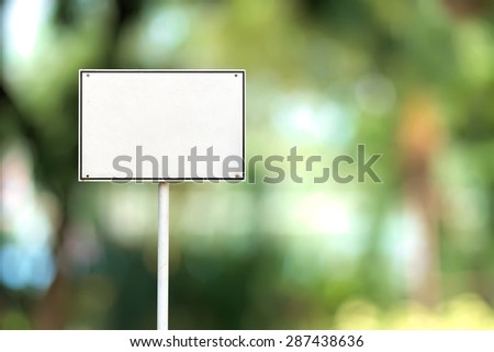 Abstract empty rectangular white sign over blurred public park background