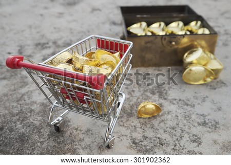 Concept of gold treasuring into treasure chest by pushcart with a gold drop on its\' side. The chinese words are crafted into gold with meaning of good fortune, best of luck, and good health.
