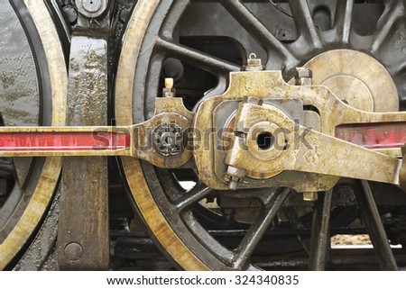 Closeup of train engine's steel shaft driving steel wheel