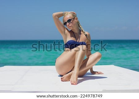 Blonde model on the boat deck  posing in sunglasses