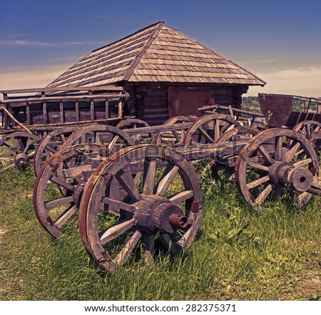 the remains of wooden carts on the background of abandoned wooden houses