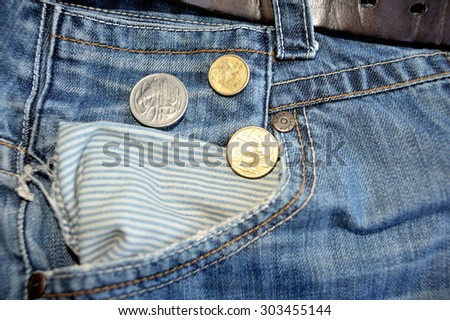 Old jeans and australian dollars coins near empty pocket