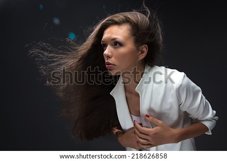 Woman holding hand on heart on black background