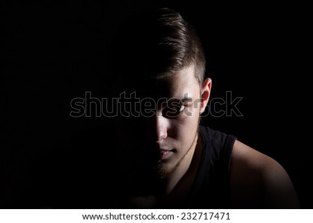 Photo of the man in shadow on black background