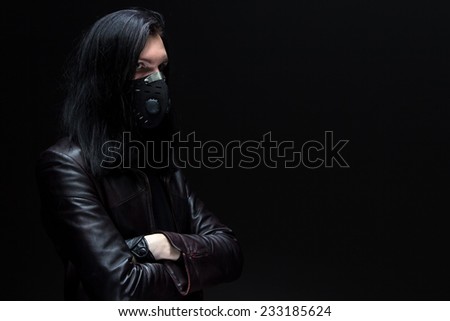 Portrait of the brunet man in mask on black background