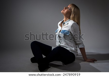 Photo of woman sitting with crossed legs on gray background
