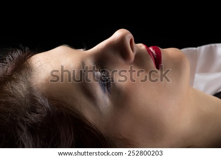 Photo of lying woman in profile on black background