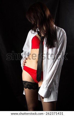 Image of woman in men\'s shirt and bowed head on black background