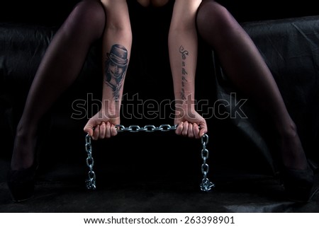 Photo of sitting woman with chains on black background