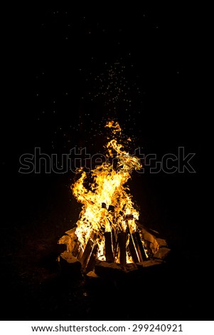 Photo of big bright campfire by night on black background
