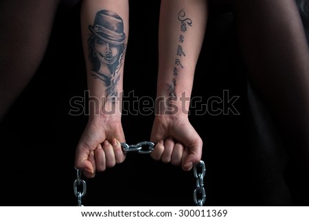 Image of woman\'s hands holding chain on black background
