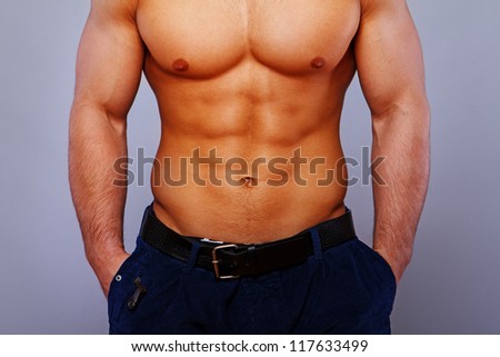 Close portrait of muscle man torso posing in studio