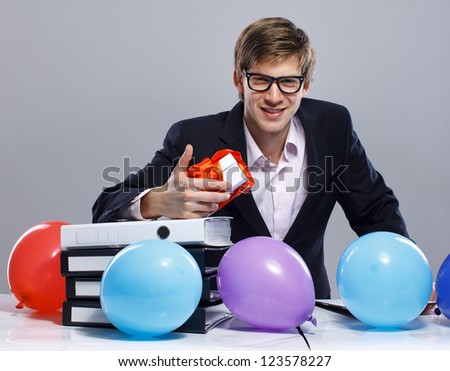 Portrait of sexy man posing in studio in front of table with color balloons
