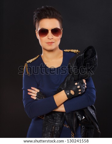 Image of well looking woman in blue dress with spikes who is holding her leather jacket