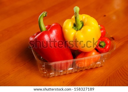 Red and yellow sweet peppers in the rectangular plastic container
