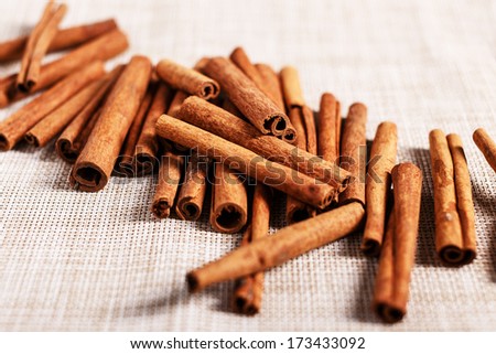 Lots of cinnamon sticks on a textured cloth