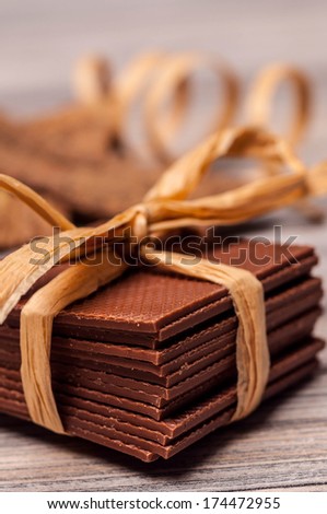 Thin pieces of chocolate stacked and tied with a ribbon