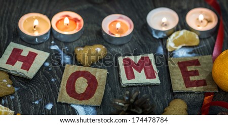Candles, mandarins, gingerbread surrounding handmade welcoming cards