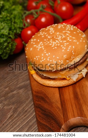 Wooden cutting board with vegetables and a Big Mac