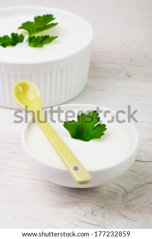 Two white bowls with white milk product in it