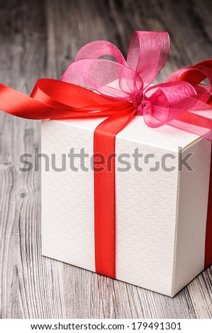 White textured gift box with red and pink ribbons