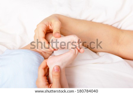 Woman holding newborn\'s feet together