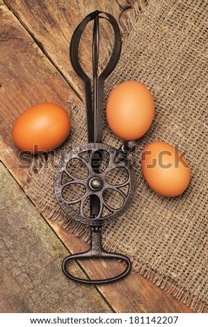 A silver vintage mixer and three raw eggs