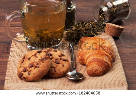 Chocolate chip cookies and a croissant with a cup of tea