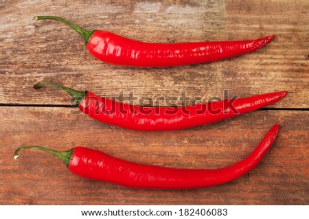 THree red hot chilli peppers on a table