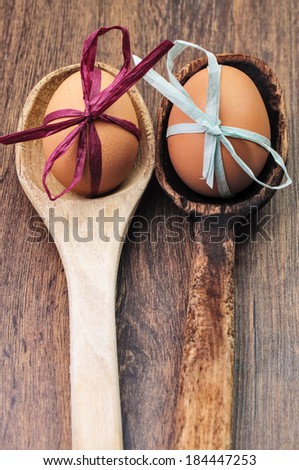 Eggs with ribbons in wooden spoons