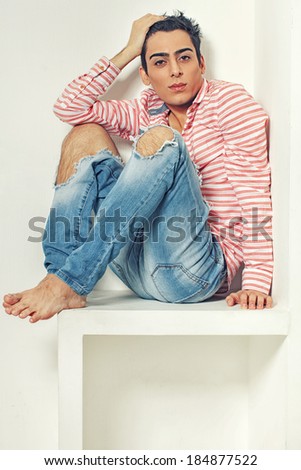 Fashionable and sweet guy portrait over a grey background