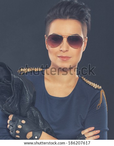Image of well looking woman in blue dress with spikes who is holding her leather jacket