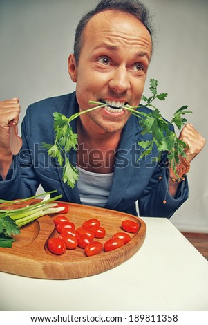 A desperate and hungry man eating grass