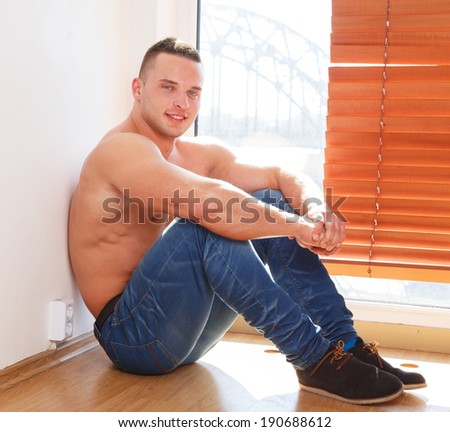 A guy in jeans and boots but no shirt