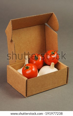 red small tomatoes with garlic close up in brown box