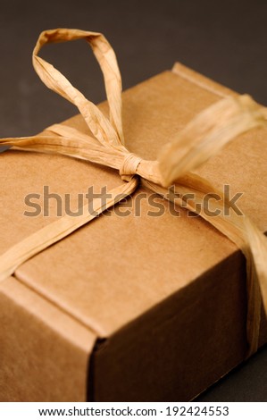 brown gift box with colored tape on grey background