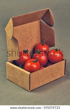 red small tomatoes close up in brown box