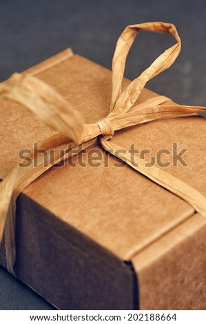 brown gift box with colored tape on grey background